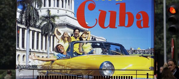 Un hombre en España sobre un bus de turismo que promociona el destino Cuba - Sputnik Mundo
