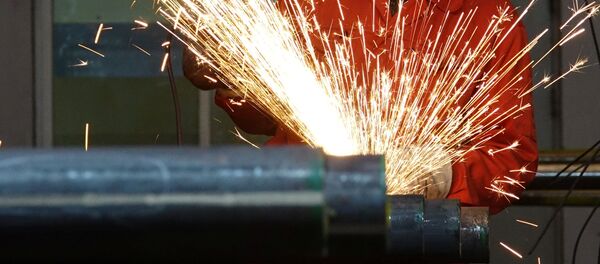 Un trabajador pule tubos de acero en una fábrica de Dongbei Special Steel Group en Dalian - Sputnik Mundo