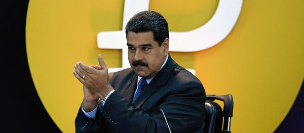 Nicolás Maduro, presidente de Venezuela, junto al logo de la criptomoneda petro - Sputnik Mundo