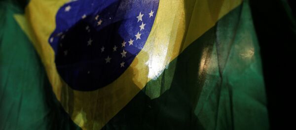 Un manifestante con la bandera de Brasil - Sputnik Mundo