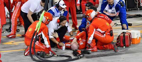 Un mecánico de Ferrari es atendido por sus compañeros después de un accidente durante durante el Gran Premio de Bahréin de F1 - Sputnik Mundo
