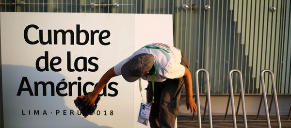 Una mujer limpia un cartel en la previa de la VIII Cumbre de las Américas en Lima, Perú. - Sputnik Mundo