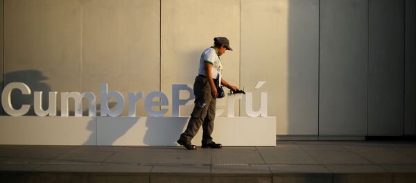 Una mujer limpia un cartel en la previa de la VIII Cumbre de las Américas en Lima, Perú - Sputnik Mundo