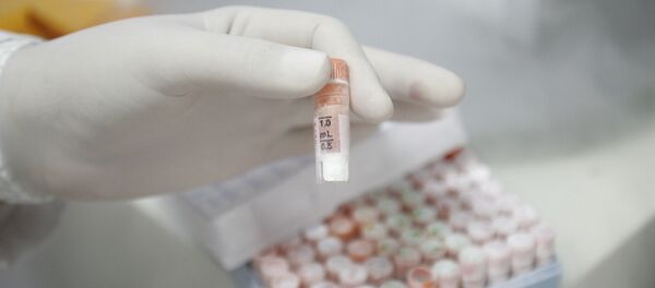 Un investigador sostiene un tubo de ensayo lleno de células madre dentro de un laboratorio del Centro de Investigación del Genoma Humano de la Universidad de Sao Paulo - Sputnik Mundo