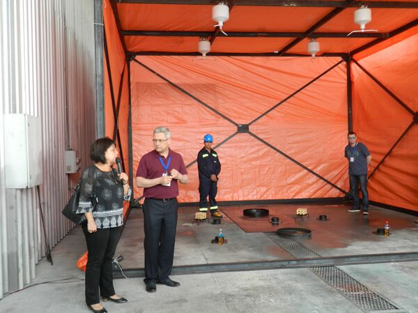 Serguéi Braguin, director de la empresa rusa LLC PC Siberian Project junto a su traductora demostrando en Montevideo módulos anti incendio Uracan - Sputnik Mundo