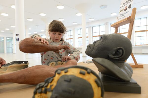 Юная участница фестиваля День недостающего звена знакомится с реконструкцией руки древнего человека Homo naledi - Sputnik Mundo