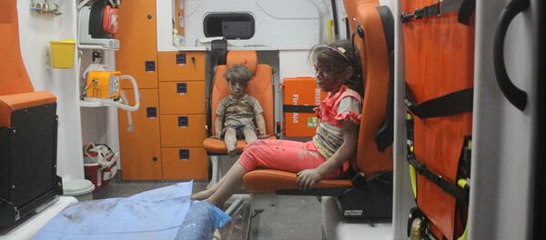 5-year-old Omran Daqneesh and his sister sit in an ambulance after being pulled out of a building hit by an airstrike in Aleppo, Syria, on Aug. 17, 2016 - Sputnik Mundo