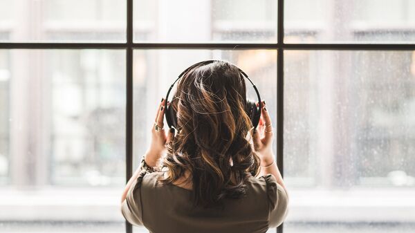 Una mujer con auriculares (imagen ilustrativa) - Sputnik Mundo