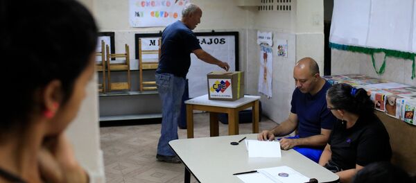 A Venezuelan casts his vote at a polling station during the presidential election in Caracas, Venezuela - Sputnik Mundo