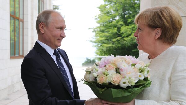 El presidente ruso Vladímir Putin regala flores a la canciller alemana, Angela Merkel El presidente ruso Vladímir Putin regala flores a la canciller alemana, Angela Merkel - Sputnik Mundo