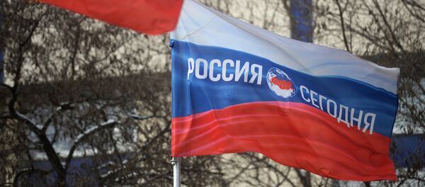 Bandera rusa con el logotipo de la Agencia de Información Internacional Rossiya Segodnya - Sputnik Mundo