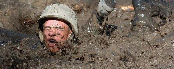 Un soldado de EEUU caído en un charco con barro - Sputnik Mundo