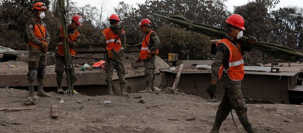 Rescatistas en un lugar afectado por la erupción del volcán de Fuego en San Juan Alotenango, Guatemala - Sputnik Mundo
