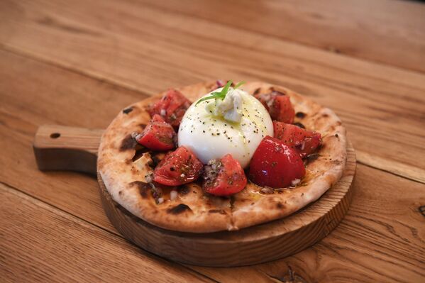 Focaccia hecha al horno con tomates y albahaca en el restaurante Quesería - Sputnik Mundo