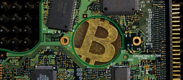 Un signo de bitcóin en una placa de computadora - Sputnik Mundo