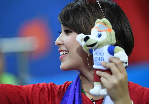 A Portuguese fan holding the FIFA World Cup 2018 symbol, posing for a photo ahead of a stage match between Spain and Portugal. - Sputnik Mundo