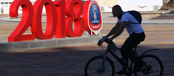 Hombre en bicicleta con el logo del Mundial de fútbol Rusia 2018 - Sputnik Mundo