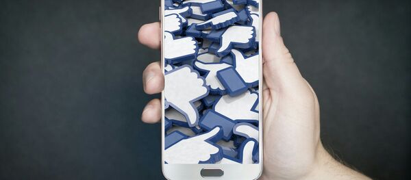 El símbolo de 'me gusta' de Facebook en una pantalla de celular El símbolo de 'me gusta' de Facebook en una pantalla de celular - Sputnik Mundo