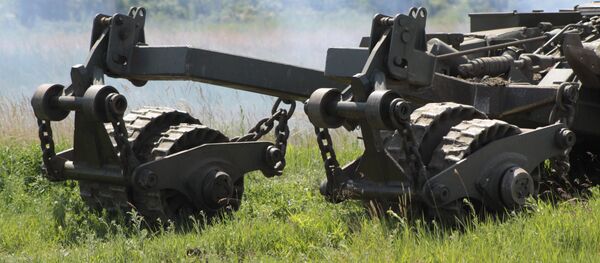 Una máquina dragaminas al lado de un tanque - Sputnik Mundo