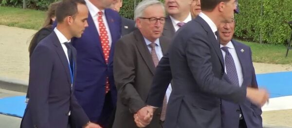In this Wednesday, July 11, 2018 grab taken from video, European Union leader Jean-Claude Juncker is helped by Netherlands Prime Minister Mark Rutte at Brussels Parc Cinquantenaire, in Brussels, Belgium. - Sputnik Mundo