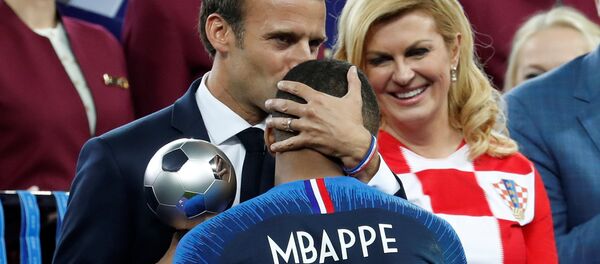 Emmanuel Macron, presidente de Francia, abraza a Kylian Mbappe, delantero de la selección francesa de fútbol, durante la ceremonia de premiación del Mundial de Rusia 2018 - Sputnik Mundo