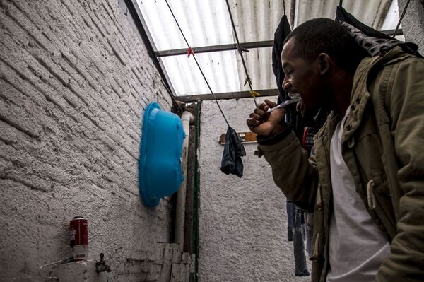 Migrante africano se lava los dientes en Casa Tochán - Sputnik Mundo