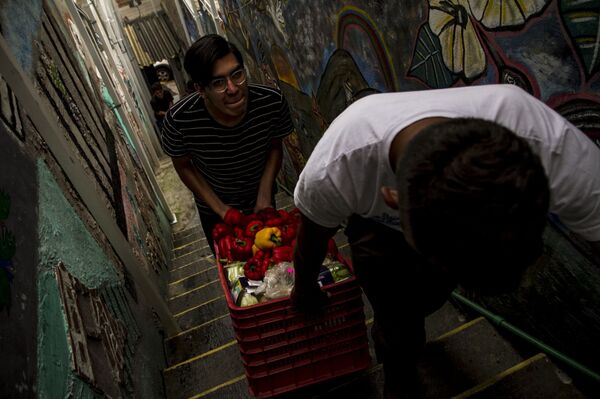 Migrantes reciben las donaciones de comida en el albergue Casa Tochán - Sputnik Mundo