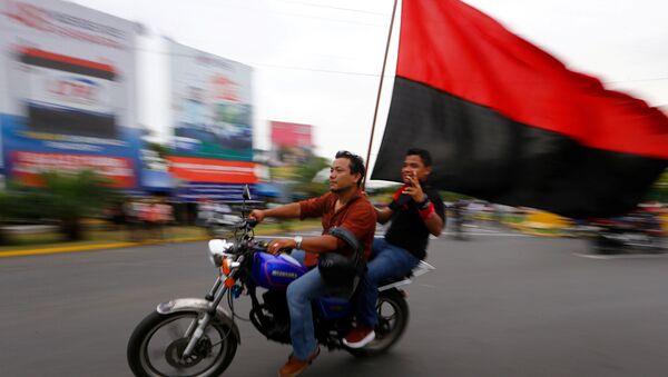 Dos motociclistas con una bandera del Frente Sandinista de Liberación Nacional de Nicaragua. Dos motociclistas con una bandera del Frente Sandinista de Liberación Nacional de Nicaragua. - Sputnik Mundo