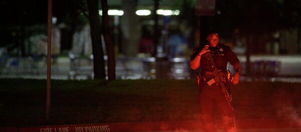 An armed police officer stands guard at a parking lot near the Curtis Culwell Center - Sputnik Mundo