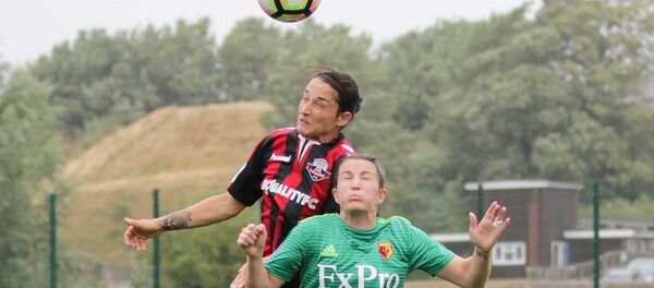 Dos futbolistas saltan para alcanzar la pelota - Sputnik Mundo