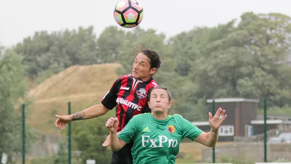 Dos futbolistas saltan para alcanzar la pelota - Sputnik Mundo