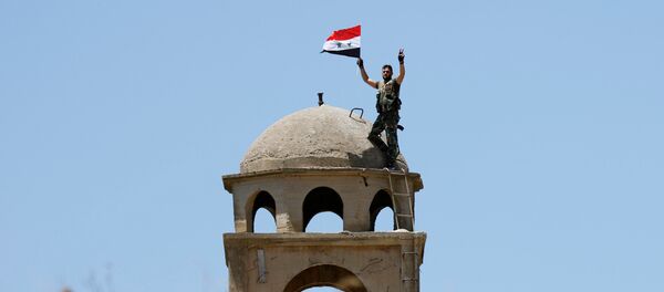 Un soldado sirio con su bandera - Sputnik Mundo