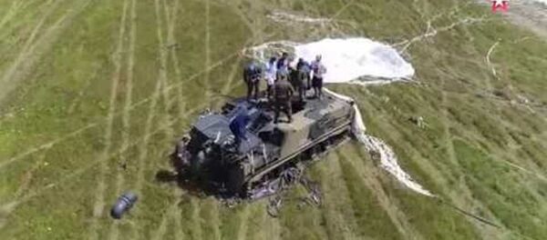 El aterrizaje en paracaídas más arriesgado: un vehículo blindado con su tripulación dentro (vídeo) - Sputnik Mundo