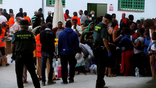Los migrantes durante una distribución de alimentos organizada por la Guardia Civil española - Sputnik Mundo