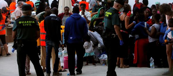 Los migrantes durante una distribución de alimentos organizada por la Guardia Civil española - Sputnik Mundo