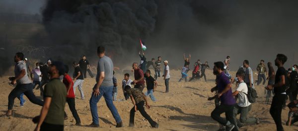 Tear gas canisters are fired by Israeli troops towards Palestinian demonstrators as they run during a protest demanding the right to return to their homeland at the Israel-Gaza border, in the southern Gaza Strip Tear gas canisters are fired by Israeli troops towards Palestinian demonstrators as they run during a protest demanding the right to return to their homeland at the Israel-Gaza border, in the southern Gaza Strip - Sputnik Mundo