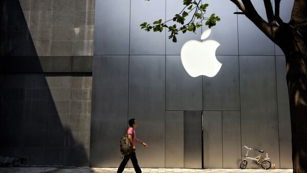 Un hombre camina al lado de una recién abierta tienda de Apple - Sputnik Mundo