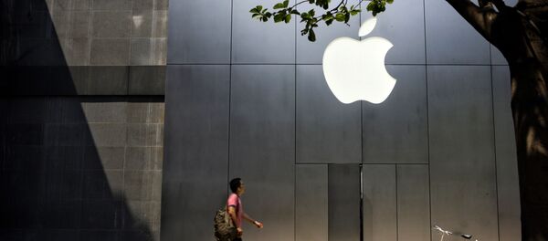 Un hombre camina al lado de una recién abierta tienda de Apple - Sputnik Mundo