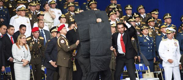 Personal de seguridad rodea al presidente de Venezuela, Nicolás Maduro, durante un incidente mientras daba un discurso en Caracas - Sputnik Mundo