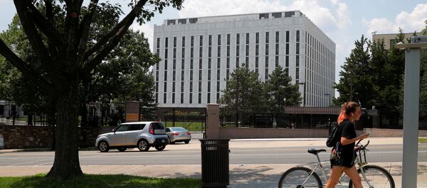Una mujer empuja su bicicleta frente la Embajada de Rusia en Washington, EEUU, el 6 de agosto de 2018 - Sputnik Mundo