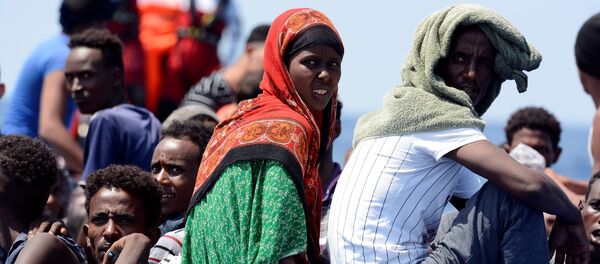 Migrantes a bordo de un bote - Sputnik Mundo