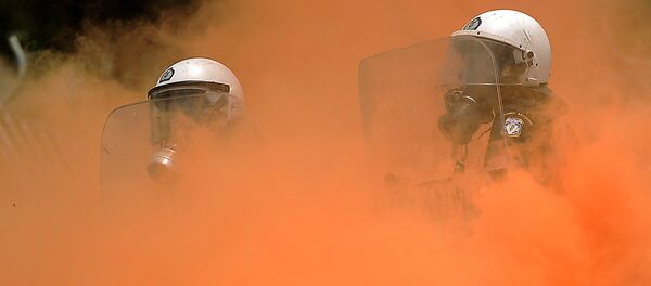 Policías antidisturbios en el humo durante los enfrentamientos con manifestantes frente al Parlamento griego el 29 de junio de 2011 en Atenas - Sputnik Mundo