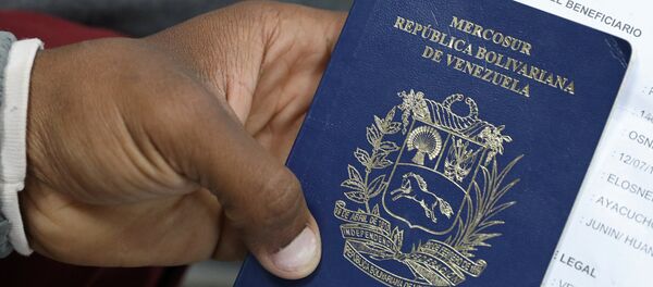 Un migrante venezolano muestra su pasaporte - Sputnik Mundo