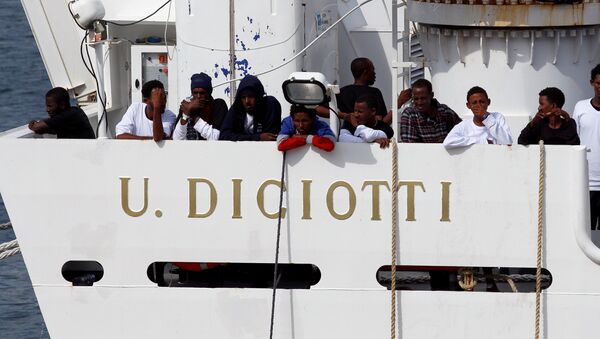 Los migrantes esperan para desembarcar del barco de la guardia costera italiana Diciotti - Sputnik Mundo