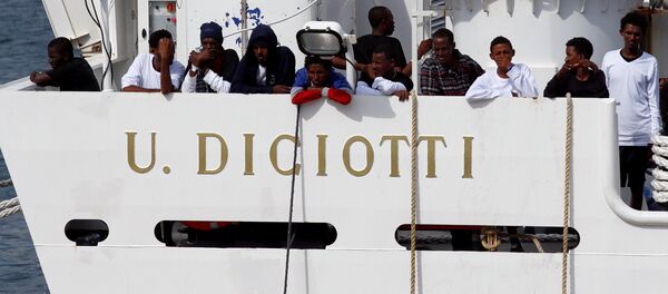 Los migrantes esperan para desembarcar del barco de la guardia costera italiana Diciotti - Sputnik Mundo