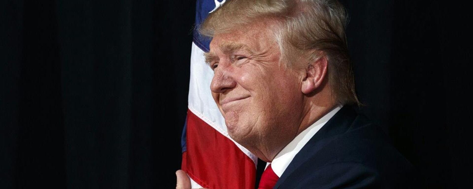 El presidente Donald Trump abraza la bandera de EEUU (archivo) - Sputnik Mundo, 1920, 16.10.2018