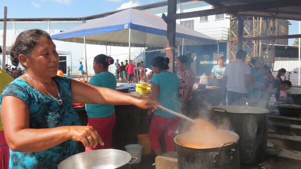 Una venezolana Warao cocina en el albergue de Pacaraima - Sputnik Mundo
