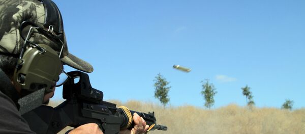 Un hombre lanza disparos con un rifle FAL - Sputnik Mundo