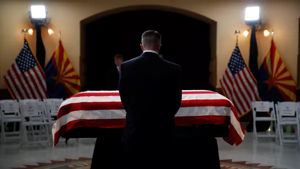 Una persona delante del ataúd del senador John McCain - Sputnik Mundo