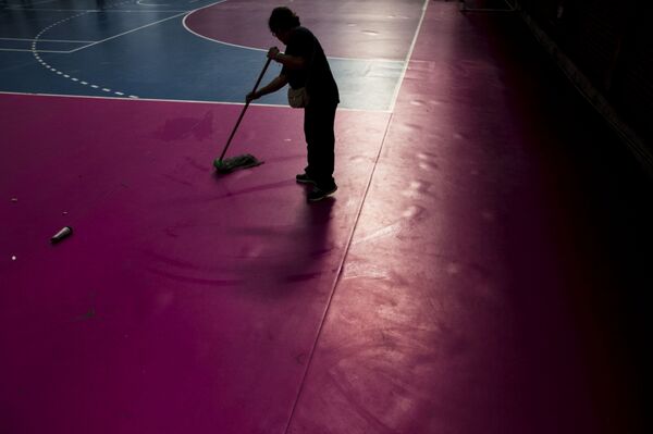Empleada limpia el piso dónde se realizó el Torneo Nacional de Artes Marciales Mixtas - Sputnik Mundo